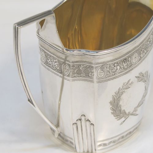 A very pretty Antique Victorian Sterling Silver milk or cream jug, having a panelled oval mainly straight-sided body, with hand-engraved bands of floral decoration, and hand-chased half-fluted corners, a gold-gilt interior, an applied reeded border, a scroll handle with flat top, and sitting on a flat base. This beautiful antique silver cream or milk jug was made by J. B. Carrington of London in 1887. The dimensions of this fine hand-made antique silver jug are height 10 cms (4 inches), length 12.5 cms (5 inches), and it weighs approx. 137g (4.4 troy ounces).  