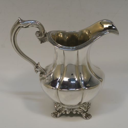 A very pretty and large Antique early Victorian Sterling Silver milk or cream jug, having a round body with hand-chased melon fluting, an applied reeded top border, a scroll handle with anthemion leaf thumb-piece, a gold-gilt interior, and all sitting on four cast foliate feet. This beautiful silver milk jug was made by Hayne and Cater of London in 1837. The dimensions of this fine hand-made antique silver cream jug are height 14 cms (4.5 inches), length 15 cms (6 inches), and it weighs approx. 237g (7.6 troy ounces).  