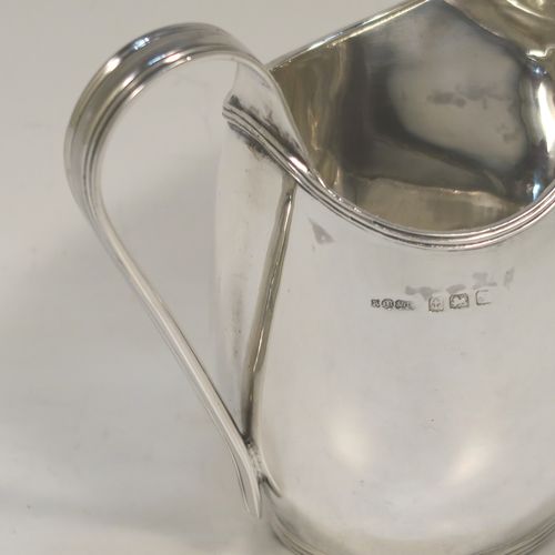 A very elegant Sterling Silver cream jug, having a plain oval bellied body, an applied reeded border and reeded scroll handle, and all sitting on a flat base. This handsome silver cream jug was made by A. Marston and Co., of Birmingham in 1933. The dimensions of this fine hand-made sterling silver cream jug are height 11 cms (4.25 inches), length 12 cms (4.75 inches), and it weighs approx. 164g (5.3 troy ounces). 