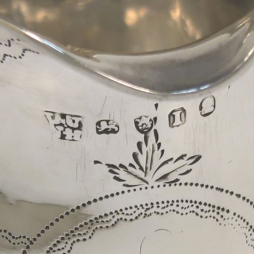 A very pretty Antique Georgian Sterling Silver cream jug, having a round bellied body with hand-engraved bands of stipple and floral work, an applied reeded border and reeded scroll handle, and all sitting on a flat base. This elegant antique silver cream jug was made by Urquart and Hart of London in 1786. The dimensions of this fine hand-made antique silver cream jug are height  cms (3.75 inches), length 11 cms (4.3 inches), and it weighs approx. 78g (2.5 troy ounces).   