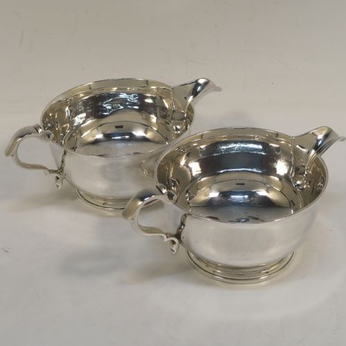 A heavy and very stylish pair of Sterling Silver sauce boats, having plain round bellied bodies, with sparrow beak spouts, cast scroll side-handles, and sitting on round collet feet. This handsome pair of sterling silver sauce boats were made by Tessier Ltd., of London in 1960. The dimensions of this fine pair of hand-made sauce boats are length 16 cms (6.25 inches), height 6.5 cms (2.75 inches), diameter 10 cms (4 inches), and they weigh a total of approx. 480g (15.5 troy ounces).   