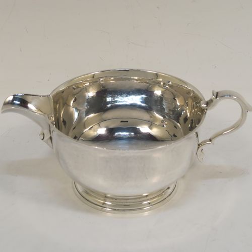 A heavy and very stylish pair of Sterling Silver sauce boats, having plain round bellied bodies, with sparrow beak spouts, cast scroll side-handles, and sitting on round collet feet. This handsome pair of sterling silver sauce boats were made by Tessier Ltd., of London in 1960. The dimensions of this fine pair of hand-made sauce boats are length 16 cms (6.25 inches), height 6.5 cms (2.75 inches), diameter 10 cms (4 inches), and they weigh a total of approx. 480g (15.5 troy ounces).   