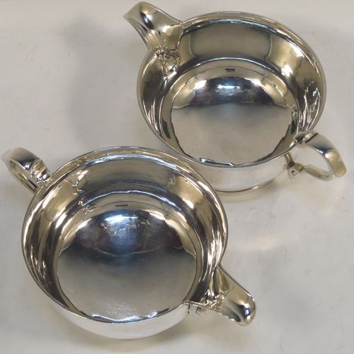 A heavy and very stylish pair of Sterling Silver sauce boats, having plain round bellied bodies, with sparrow beak spouts, cast scroll side-handles, and sitting on round collet feet. This handsome pair of sterling silver sauce boats were made by Tessier Ltd., of London in 1960. The dimensions of this fine pair of hand-made sauce boats are length 16 cms (6.25 inches), height 6.5 cms (2.75 inches), diameter 10 cms (4 inches), and they weigh a total of approx. 480g (15.5 troy ounces).   