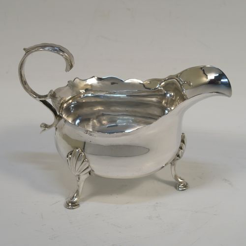 A handsome Antique Georgian Sterling Silver cream boat, having a plain bellied body, with a Chippendale style top border, a flying scroll side-handle, and sitting on three cast hoof feet with shell shoulders. This beautiful antique silver cream boat was made by William Skeen of London in 1771. The dimensions of this fine hand-made silver cream boat are Length 12 cms (4.75 inches), height 8.5 cms (3.3 inches), and it weighs approx. 82g (2.6 troy ounces).  