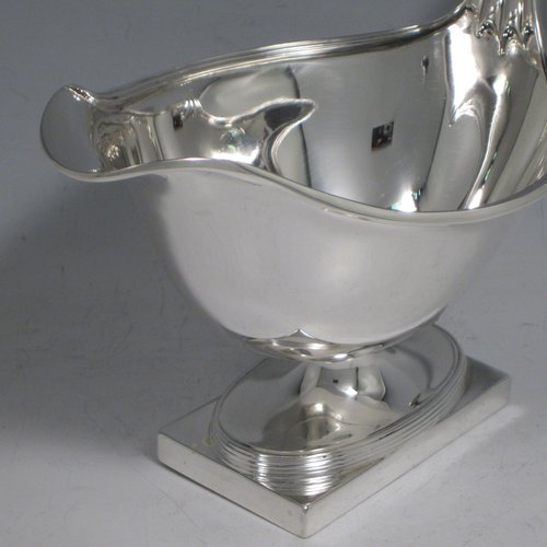 Antique sterling silver pair of large sauce or gravy boats, having plain oval baluster bodies, applied reeded borders, reeded loop handles, and sitting on pedestal feet with rectangular bases. Made by Hawksworth & Eyre Co. Ltd., of London in 1911. The dimensions of these fine hand-made antique silver sauce boats are length 18.5 cms (7.25 inches), width 11 cms (4.25 inches), height 12.5 cms (5 inches), and they weigh a total of 650g (21 troy ounces).   