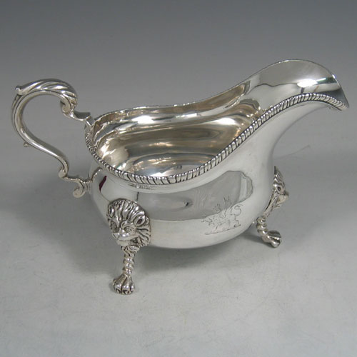 An Antique Victorian sterling silver single large sauce boat, having a plain baluster body, with an applied gadroon border, a cast scroll handle, and sitting on three cast lion-mask feet. Made by Frederick Brasted of London in 1870. The dimensions of this fine hand-made silver sauce boat are length 19.5 cms (7.75 inches), height 11.4 cms (4.5 inches), width 10 cms (4 inches), and it weighs approx. 384g (12.4 troy ounces). Please note that this item is crested.