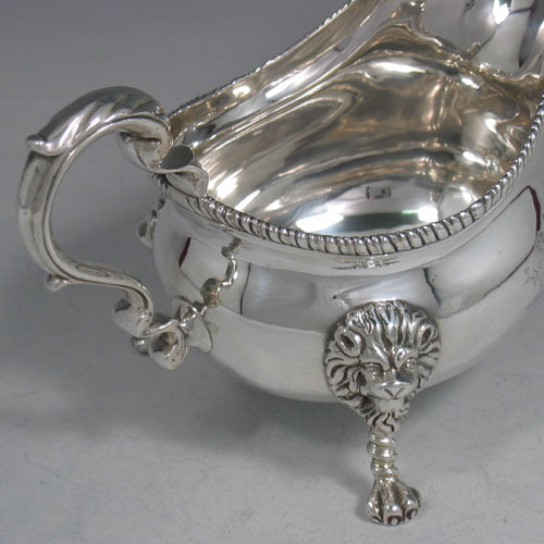 An Antique Victorian sterling silver single large sauce boat, having a plain baluster body, with an applied gadroon border, a cast scroll handle, and sitting on three cast lion-mask feet. Made by Frederick Brasted of London in 1870. The dimensions of this fine hand-made silver sauce boat are length 19.5 cms (7.75 inches), height 11.4 cms (4.5 inches), width 10 cms (4 inches), and it weighs approx. 384g (12.4 troy ounces). Please note that this item is crested.