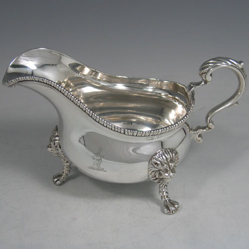 An Antique Victorian sterling silver single large sauce boat, having a plain baluster body, with an applied gadroon border, a cast scroll handle, and sitting on three cast lion-mask feet. Made by Frederick Brasted of London in 1870. The dimensions of this fine hand-made silver sauce boat are length 19.5 cms (7.75 inches), height 11.4 cms (4.5 inches), width 10 cms (4 inches), and it weighs approx. 384g (12.4 troy ounces). Please note that this item is crested.