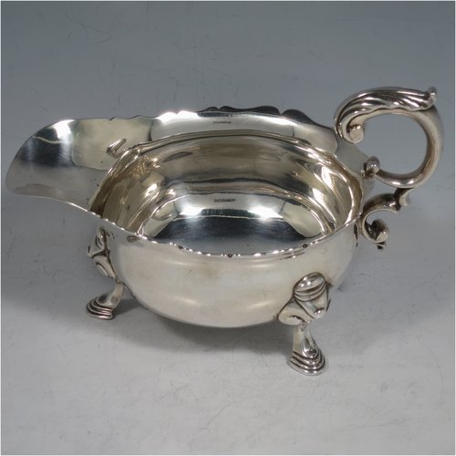 An Antique Georgian Sterling Silver George II sauce or gravy boat, having a plain baluster body, with a Chippendale border, cast scroll handle, and sitting on three cast hoof feet with scroll shoulders. Made in London in 1746. The dimensions of this fine hand-made antique silver sauce boat are length 16.5 cms (6.5 inches), width 10 cms (4 inches), height 10 cms (4 inches), and it weighs 280g (9 troy ounces). Please note that this item is crested.