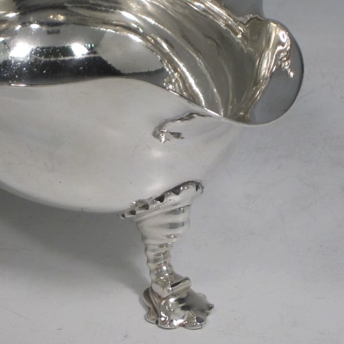 Antique Georgian sterling silver pair of large George II sauce or gravy boats, having plain baluster bodies, with Chippendale borders, cast scroll handles, and sitting on three unusual shell-style cast feet. Made by William Cripps of London in 1746. The dimensions of these fine hand-made antique silver sauce boats are length 21 cms (8.25 inches), width 11.5 cms (4.5 inches), height 10 cms (4 inches), and they weigh a total of 713g (23 troy ounces).   