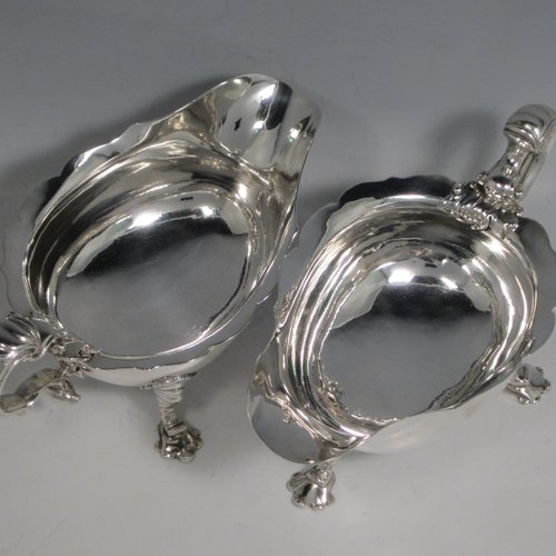 Antique Georgian sterling silver pair of large George II sauce or gravy boats, having plain baluster bodies, with Chippendale borders, cast scroll handles, and sitting on three unusual shell-style cast feet. Made by William Cripps of London in 1746. The dimensions of these fine hand-made antique silver sauce boats are length 21 cms (8.25 inches), width 11.5 cms (4.5 inches), height 10 cms (4 inches), and they weigh a total of 713g (23 troy ounces).   