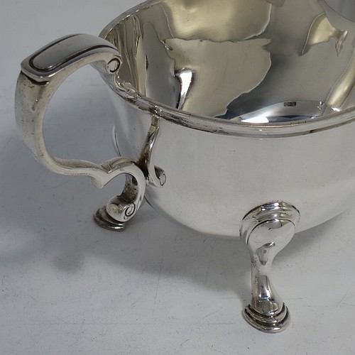 A very handsome Sterling Silver pair of sauce boats or gravy boats in a Georgian style, having plain bellied bodies, with applied Reeded borders, cast scroll handles, and sitting on three cast hoof feet. Made by Wakely & Wheeler of London in 1933. The dimensions of these fine hand-made silver gravy or sauce boats are length 16 cms (6.25 inches), width 8 cms (3 inches), height 8 cms (3.25 inches), and they weigh a total of approx. 381g (12.3 troy ounces).    