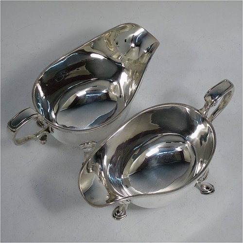 A very handsome Sterling Silver pair of sauce boats or gravy boats in a Georgian style, having plain bellied bodies, with applied Reeded borders, cast scroll handles, and sitting on three cast hoof feet. Made by Wakely & Wheeler of London in 1933. The dimensions of these fine hand-made silver gravy or sauce boats are length 16 cms (6.25 inches), width 8 cms (3 inches), height 8 cms (3.25 inches), and they weigh a total of approx. 381g (12.3 troy ounces).    