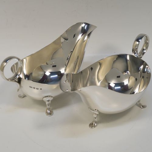 A very stylish pair of Sterling Silver sauce boats, having plain round bellied bodies, with ring side-handles, and sitting on three hoof feet. This handsome pair of sterling silver sauce boats were made by James Dixon and Sons of Sheffield in 1931. The dimensions of this fine pair of hand-made sauce boats are length 18 cms (7 inches), height 10 cms (2 inches), and they weigh a total of approx. 424g (13.7 troy ounces).   