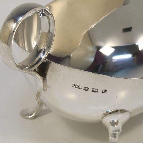 A very stylish pair of Sterling Silver sauce boats, having plain round bellied bodies, with ring side-handles, and sitting on three hoof feet. This handsome pair of sterling silver sauce boats were made by James Dixon and Sons of Sheffield in 1931. The dimensions of this fine pair of hand-made sauce boats are length 18 cms (7 inches), height 10 cms (2 inches), and they weigh a total of approx. 424g (13.7 troy ounces).   