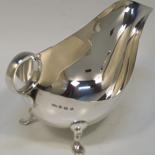 A very stylish pair of Sterling Silver sauce boats, having plain round bellied bodies, with ring side-handles, and sitting on three hoof feet. This handsome pair of sterling silver sauce boats were made by James Dixon and Sons of Sheffield in 1931. The dimensions of this fine pair of hand-made sauce boats are length 18 cms (7 inches), height 10 cms (2 inches), and they weigh a total of approx. 424g (13.7 troy ounces).   