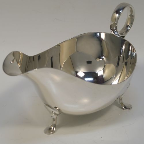 A very stylish pair of Sterling Silver sauce boats, having plain round bellied bodies, with ring side-handles, and sitting on three hoof feet. This handsome pair of sterling silver sauce boats were made by James Dixon and Sons of Sheffield in 1931. The dimensions of this fine pair of hand-made sauce boats are length 18 cms (7 inches), height 10 cms (2 inches), and they weigh a total of approx. 424g (13.7 troy ounces).   