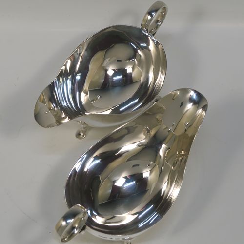 A very stylish pair of Sterling Silver sauce boats, having plain round bellied bodies, with ring side-handles, and sitting on three hoof feet. This handsome pair of sterling silver sauce boats were made by James Dixon and Sons of Sheffield in 1931. The dimensions of this fine pair of hand-made sauce boats are length 18 cms (7 inches), height 10 cms (2 inches), and they weigh a total of approx. 424g (13.7 troy ounces).   