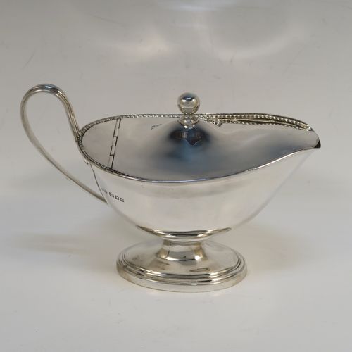 A handsome and rare Antique Edwardian Sterling Silver covered sauce boat, having a plain oval bellied body, with an applied rope-twist top border, a reeded scroll side handle, a hinged domed lid with a ball finial, and all sitting on an oval pedestal foot. This elegant antique silver covered sauce boat was made by Alstons and Hallam  of London in 1904. The dimensions of this fine hand-made antique silver covered sauce boat are length 19 cms (7.5 inches), width 10 cms (4 inches), height 12 cms (4.75 inches), and it weighs 463g (14.9 troy ounces).   