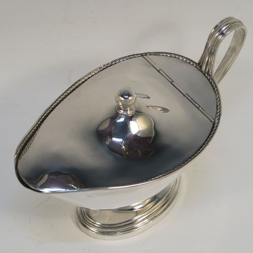 A handsome and rare Antique Edwardian Sterling Silver covered sauce boat, having a plain oval bellied body, with an applied rope-twist top border, a reeded scroll side handle, a hinged domed lid with a ball finial, and all sitting on an oval pedestal foot. This elegant antique silver covered sauce boat was made by Alstons and Hallam  of London in 1904. The dimensions of this fine hand-made antique silver covered sauce boat are length 19 cms (7.5 inches), width 10 cms (4 inches), height 12 cms (4.75 inches), and it weighs 463g (14.9 troy ounces).   