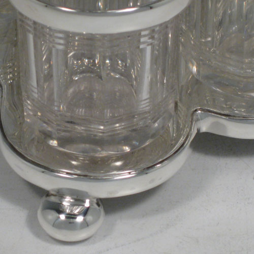 Antique Victorian sterling silver cruet set, having a plain stand with ring handle and frame for six hand-cut crystal cruet bottles with original stoppers and silver mounts, all sitting on a base with four cushion feet. Made by William Hutton and Sons of Sheffield in 1901. Height 22 cms (8.75 inches), length 16.5 cms (6.5 inches), width 13 cms (5 inches). Total weight approx. 650g (21 troy ounces). 