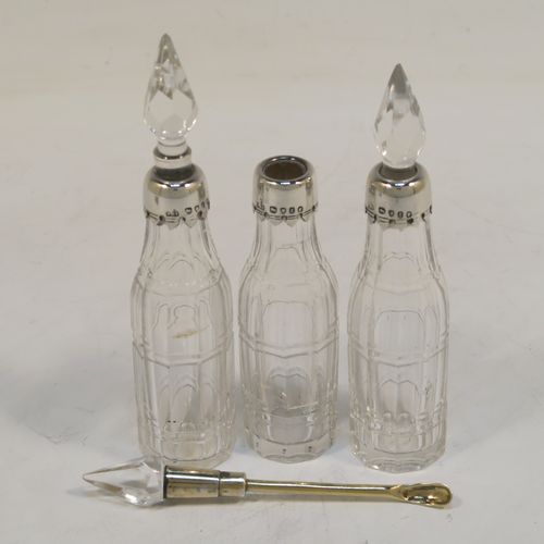 A small but very pretty Antique Victorian Sterling Silver and crystal bottle cruet set, having a plain frame with applied reeded borders, a matching side-handle with thumb-piece, three original crystal bottles with stoppers and silver collars, two for oil and vinegar and the third for mustard or chili sauce with its original gold-gilt spoon, all sitting on a base with three flange feet. This beautiful cruet set was made by Francis Boone Thomas of London in 1873. The dimensions of this fine hand-made antique silver cruet set are height 13.5 cms (5.3 inches), length 7.5 cms (3 inches), and width 6 cms (2.3 inches).    