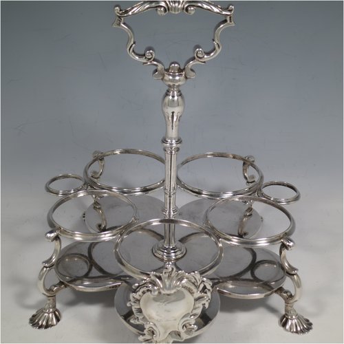 An Antique Georgian Sterling Silver and hand-cut crystal five-bottle Warwick style cruet set, having a stand with ring & scroll work holders, a cast loop handle with shell, a cast applied shell-style cartouche, and sitting on four cast shell feet. With two smaller baluster style pepper pots, a larger baluster sugar caster, and two hand-cut crystal oil & vinegar bottles with silver tops. Made by Samuel Woods of London in 1752-1754. The dimensions of this fine hand-made silver cruet set are width of stand 20 cms (8 inches), height of stand 23 cms (9 inches), and weight of silver approx. 1,500g (48 troy ounces). Please note that the silver tops on the crystal bottles are unmarked, and the stand is crested.   