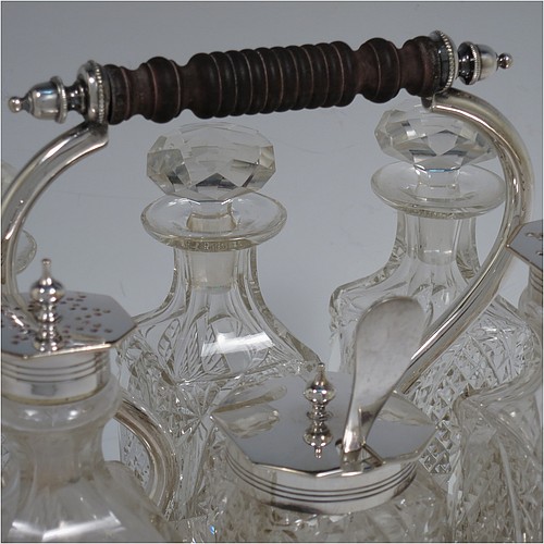 A very pretty Antique Victorian Silver Plated and hand-cut crystal cruet set, having six crystal bottles with original stoppers and silver mounts, sitting in a rectangular hand-pierced gallery frame with reeded borders, on four cast stepped feet. Made by Henry Hobson and Son, of Sheffield in ca. 1890. The dimensions of this fine hand-made antique silver-plated cruet set are height of frame 19 cms (7.5 inches), length 18.5 cms (7.3 inches), and width 14 cms (5.5 inches).   