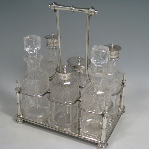    Antique Victorian sterling silver and hand-cut crystal cruet set, having six bottles with reeded mounts, sitting in a rectangular frame with bead edges, on four cushion feet. The frame was made by Walker and Hall of Sheffield in 1900, and the bottles by Bewlay & Co. of Birmingham between 1897 and 1900. Height of frame 22 cms (8.75 inches), length 18 cms (7 inches), width 13 cms (5 inches). Weight of stand approx. 729g (23.5 troy ounces).