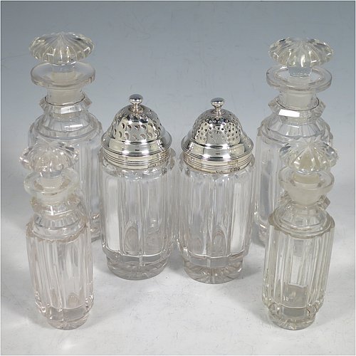 An Antique Georgian Sterling Silver large table cruet set, having a Regency style rectangular  stand with an applied gadroon border, with ring handle and a frame for six hand-cut crystal cruet bottles with original stoppers and silver mounts, all sitting on a base with four cast lions paw  feet. Made by William Bateman I of London in 1825. The dimensions of this fine antique silver cruet set are height 20 cms (8 inches), length 15 cms (6 inches), and width 13 cms (5 inches). Please note that the base has a wooden insert underneath.   