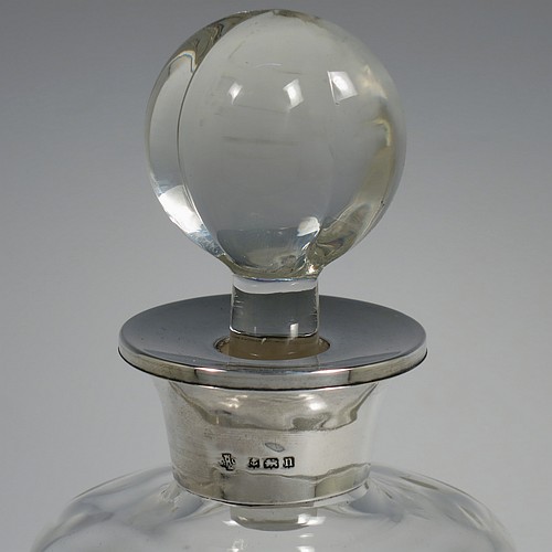 A pair of Antique Sterling Silver and cut-crystal decanters, having plain panelled bodies, plain round silver necks, with original hand-cut lobed stoppers, and all sitting on star-cut flat bases. Made by William Hutton and Sons Ltd., of Birmingham in 1912. The dimensions of this fine pair of antique silver and crystal decanters are height 27 cms (10.75 inches), and diameter at bases 10 cms (4 inches).