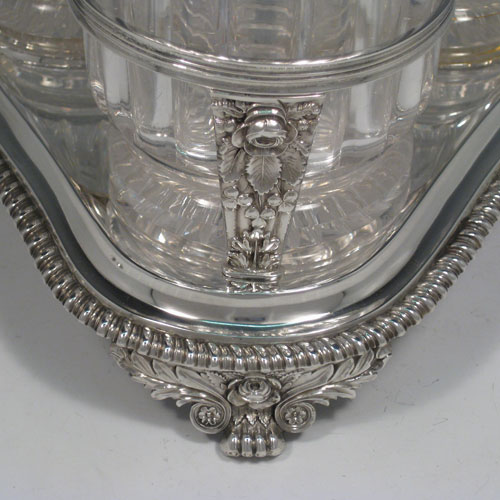    Antique Georgian sterling silver decanter stand with three decanters and frame with gadroon and rose borders. Made by William Bateman of London in 1824. Height 32 cms (12.5 inches), width 23 cms (9 inches). Weight 31.5 troy ounces (977g).