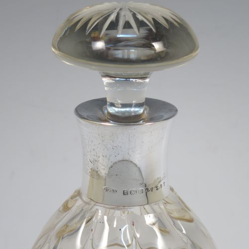 A very unusually designed Sterling Silver and hand-cut crystal decanter, having an oval body , and with hand-cut reeded decoration together with internal lobed work, a plain silver collar, an original hand-cut stopper, and sitting on a flat base with a star-cut. Made by John Grinsell of Birmingham in 1910. The dimensions of this fine hand-made silver and crystal decanter are height 25.5 cms (10 inches), and diameter 10 cms (4 inches).  