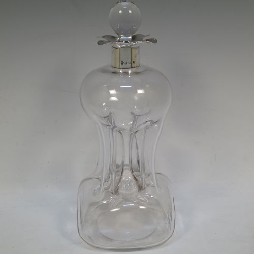 A handsome Antique Victorian Sterling Silver and cut-crystal glug-glug decanter, having a plain and clear body with pinched and fluted central waists, a plain round neck with four pouring spouts, and original hand-cut stopper. Made by William Hutton and Sons of Birmingham in 1901. The dimensions of this fine hand-made antique silver and crystal glug glug decanter are height 27.5 cms (10.75 inches), and width at base 13 cms (5 inches).  