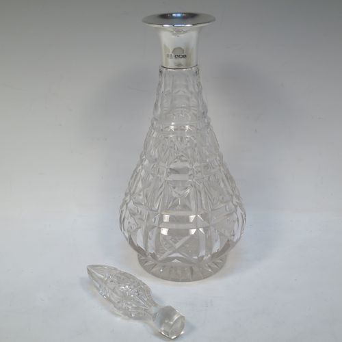 A very handsome Antique Sterling Silver and hand-cut crystal decanter, having a tear-drop shaped body with tapering sides, with hand-cut geometrical decoration, a silver collar and lip, and with original stopper. This elegant silver and crystal decanter was made by R. F. Mosley and Co., of of Sheffield in 1922. The dimensions of this fine hand-made antique silver and crystal decanter are height 32.5 cms (12.75 inches), and diameter at base 11.5 cms (4.5 inches).   