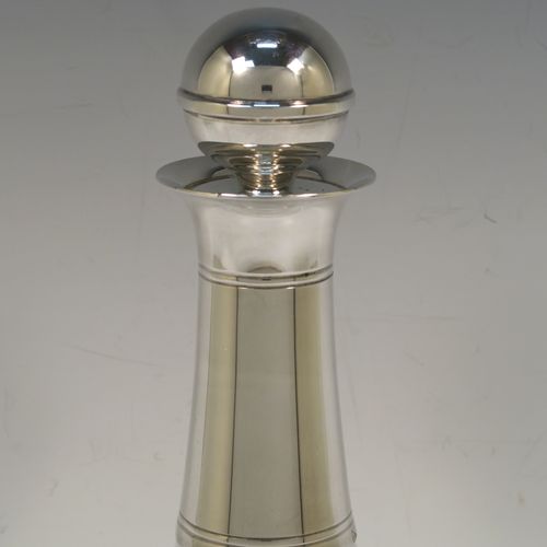 A very elegant Silver Plated and hand-blown glass bodied decanter, having a plain round silver-plated long neck with two bands of hand-chased reeded decoration, an original plain round silver-plated stopper, and a plain round glass body. This handsome silver-plated decanter was made in ca. 1960. The dimensions of this fine hand-made  silver plated and glass decanter are height 26 cms (10.25 inches), and 13.5 cms (5.25 inches) in diameter at its widest point.   