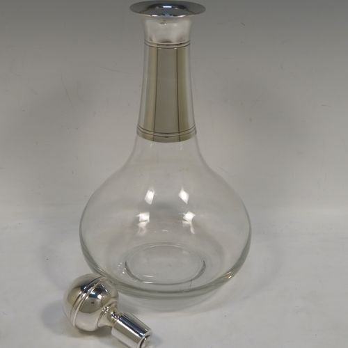 A very elegant Silver Plated and hand-blown glass bodied decanter, having a plain round silver-plated long neck with two bands of hand-chased reeded decoration, an original plain round silver-plated stopper, and a plain round glass body. This handsome silver-plated decanter was made in ca. 1960. The dimensions of this fine hand-made  silver plated and glass decanter are height 26 cms (10.25 inches), and 13.5 cms (5.25 inches) in diameter at its widest point.   