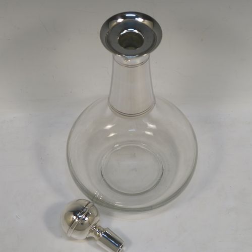 A very elegant Silver Plated and hand-blown glass bodied decanter, having a plain round silver-plated long neck with two bands of hand-chased reeded decoration, an original plain round silver-plated stopper, and a plain round glass body. This handsome silver-plated decanter was made in ca. 1960. The dimensions of this fine hand-made  silver plated and glass decanter are height 26 cms (10.25 inches), and 13.5 cms (5.25 inches) in diameter at its widest point.   