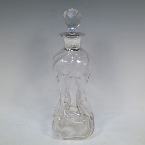 A very pretty Antique Edwardian Sterling Silver and cut-crystal glug-glug decanter, having swirl-flute shoulders and clear bottom body, with four pinched and fluted central waists between, a plain round neck mount, and a hand-cut spherical and faceted crystal stopper. Made in Birmingham in 1909. The dimensions of this fine hand-made antique silver and crystal glug glug decanter are height 28.5 cms (11.25 inches), and width at base 11.5 cms (4.5 inches). 