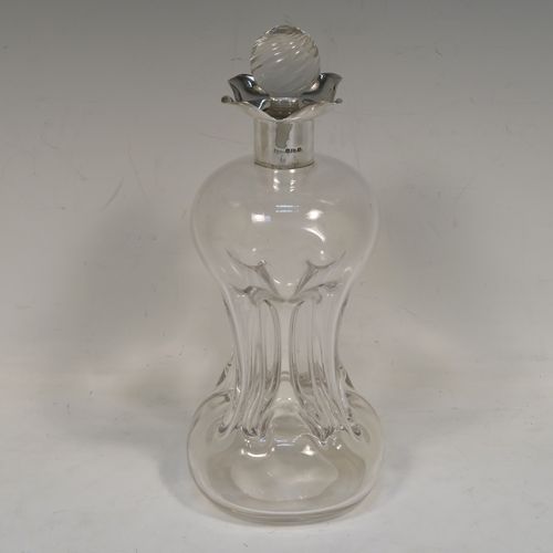 A very pretty Antique Victorian Sterling Silver and hand-cut crystal glug-glug decanter, having a plain body with four pinched and fluted central waists between, a plain round neck mount with four spouts, and a swirl fluted crystal stopper. This beautiful antique silver and crystal decanter was made by William Hammon of Chester in 1895. The dimensions of this fine hand-made antique silver and crystal glug glug decanter are height 21.5 cms (8.5 inches), and width at base 9 cms (3.5 inches).