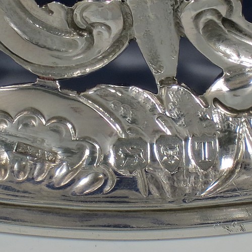 An Antique Victorian Sterling Silver large table dish ring in an Irish style, having a hand-pierced and chased body decorated with pastoral scenes, figures, animals, a vacant oval cartouche, and a blue-glass liner. Made by D. and J. Welby of London in 1894. The dimensions of this fine hand-made antique silver dish ring are height 7.5 cms (3 inches), diameter at base 19 cms (7.5 inches), and it weighs approx. 351g (11.3 troy ounces).    