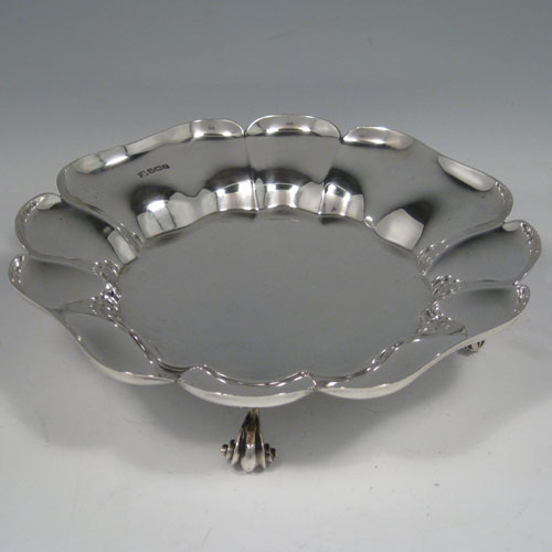 Sterling silver dish, having a clover-leaf style body, with shaped and lobed border, and sitting on four cast scroll feet. Made by Thomas Bradbury & Sons of Sheffield in 1923. The dimensions of this fine silver dish are diameter 23 cms (9 inches), height 5.5 cms (2.75 inches), and it weighs approx. 654g (21.1 troy ounces).