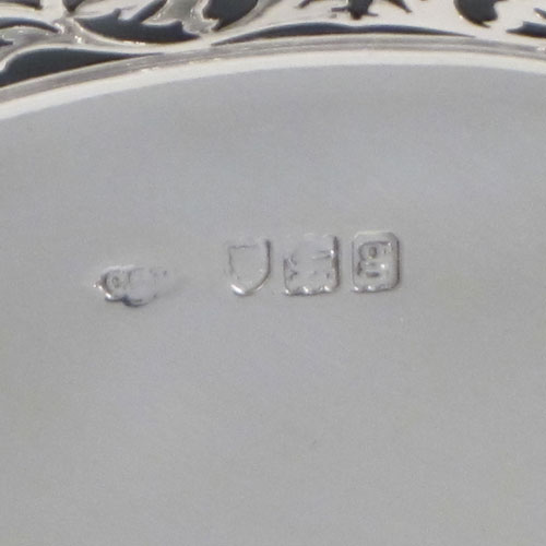 Antique Edwardian sterling silver bread roll table dish, having an oval body with hand-pierced geometrical and floral decoration, with an applied shaped reeded border, with two scroll side handles, and sitting on a flat base. Made by Charles Clement Pilling of London in 1902. The dimensions of this fine hand-made silver bread dish are length 32.5 cms (12.75 inches), width 18 cms (7 inches), height 6.5 cms (2.5 inches), and it weighs approx. 304g (9.8 troy ounces).   