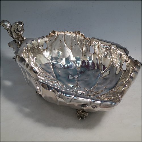 An Antique Victorian Silver Plated very unusual squirrel nut dish, having an oval body all hand-chased and made to look like half a walnut, with a cast squirrel handle, and sitting on four cast foliate feet. Made by the Pairpoint Brothers  of Sheffield in ca. 1880. The dimensions of this fine hand-made antique silver-plated bread dish are length 28 cms (11 inches), width 19 cms (7.5 inches), and height 13 cms (5 inches).    