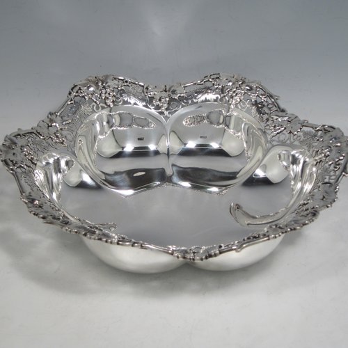 Sterling silver dish, having a shaped and lobed round body, with an applied and hand-pierced border showing grape-vine and leaf decoration, and sitting on a flat base. Made by Henry Atkins of Sheffield in 1943. The dimensions of this fine hand-made silver dish are diameter 23 cms (9 inches), height 5 cms (2 inches), and it weighs approx. 387g (12.8 troy ounces).   