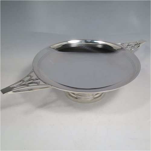 A Sterling Silver Art Deco very stylish serving dish, having a plain round body, with a band of hand-engraved reed-work, and two hand-pierced handles, all sitting on a pedestal foot. Made by William Naylor of Birmingham in 1935. The dimensions of this fine hand-made silver Art Deco dish are width across handles 36.5 cms (14.3 inches), height 7.5 cms (3 inches), and it weighs approx. 520g (16.8 troy ounces).   