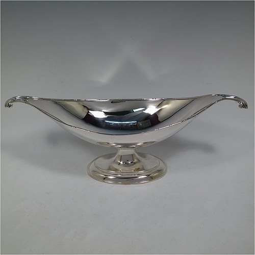 An Antique Edwardian Sterling Silver Arts and Crafts style plain oval table dish or bowl, having an applied ribbon & reed border, with fluted and scroll handles, and sitting on a stepped pedestal base. Made by Elkington & Co., of Birmingham in 1907. The dimensions of this fine hand-made antique silver Arts & Crafts bowl or dish are length 38 cms (15 inches), width 13.5 cms (5.3 inches), height 13 cms (5 inches), and it weighs of approx. 573g (18.5 troy ounces).