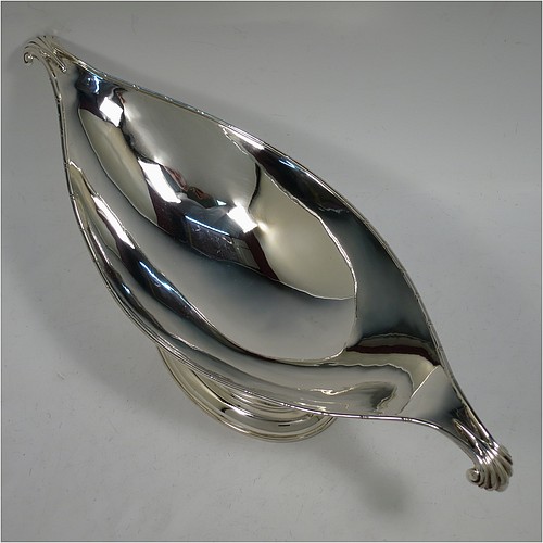 An Antique Edwardian Sterling Silver Arts and Crafts style plain oval table dish or bowl, having an applied ribbon & reed border, with fluted and scroll handles, and sitting on a stepped pedestal base. Made by Elkington & Co., of Birmingham in 1907. The dimensions of this fine hand-made antique silver Arts & Crafts bowl or dish are length 38 cms (15 inches), width 13.5 cms (5.3 inches), height 13 cms (5 inches), and it weighs of approx. 573g (18.5 troy ounces).