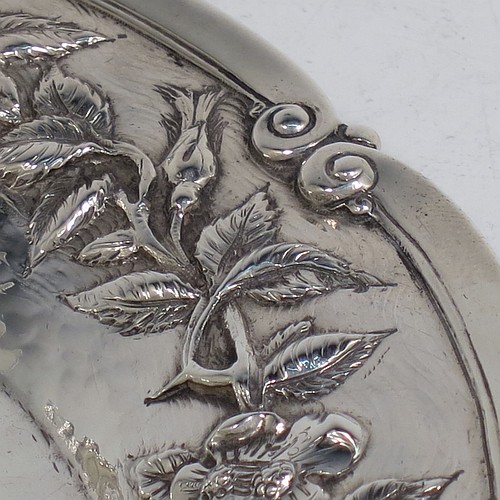 A very pretty Scottish Sterling Silver Arts and Crafts style table dish, having a round hand-hammered body, with an applied scroll border and hand-chased floral wild rose and thorn-leaf decoration. Made by Edward and Sons of Glasgow in 1922. The dimensions of this fine hand-made Arts and Crafts silver dish are diameter 18 cms (7 inches), and it weighs approx. 203g (6.5 troy ounces).    