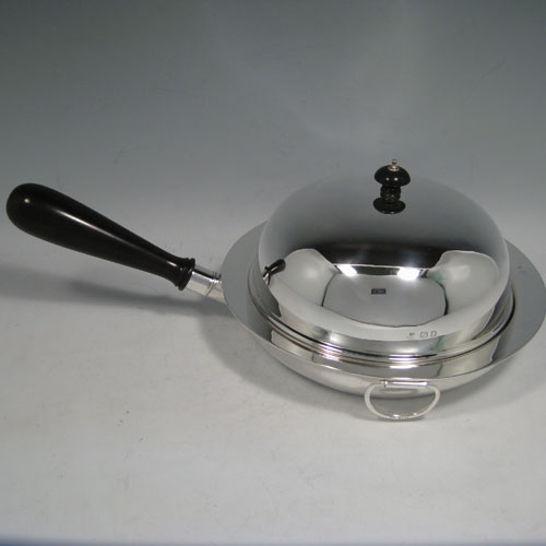 Sterling silver chafing dish, having a plain round body, a domed lid with wooden finial, a pair of loop side handles, and the body having an interior heating compartment that can be filled with hot water after unscrewing the wooden handle. Made by Charles Boyton and sons of London in 1922. The dimensions of this fine hand-made dish are length including handle 38 cms (15 inches), diameter 23 cms (9 inches), height 13 cms (5 inches), and the weight without handle is approx. 1,240g (40 troy ounces). Please note that the lid is crested.